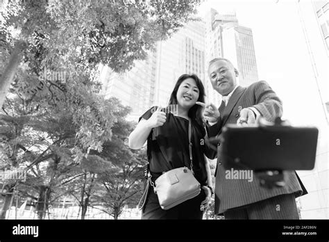 Mature Asian Businessman And Mature Asian Woman Exploring The City