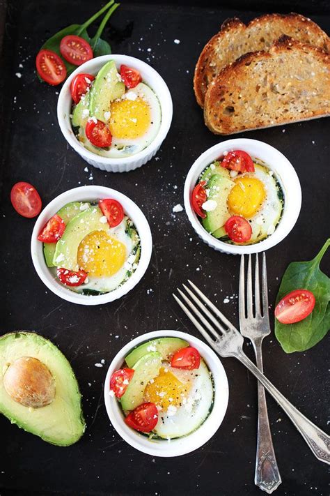 Baked Eggs With Spinach Topped With Avocado Tomatoes And Crumbled