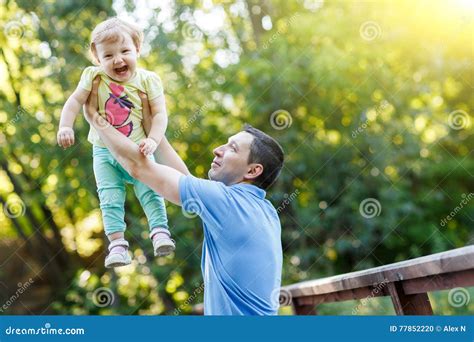 Dad Holds Baby Daughter In His Arms In Summer Park Stock Photo Image