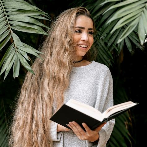 Mujer Sonriente Leyendo Un Libro Al Aire Libre Foto Gratis