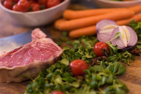 Fatia Suculenta De Bife Cru Legumes Em Uma Mesa De Madeira Foto