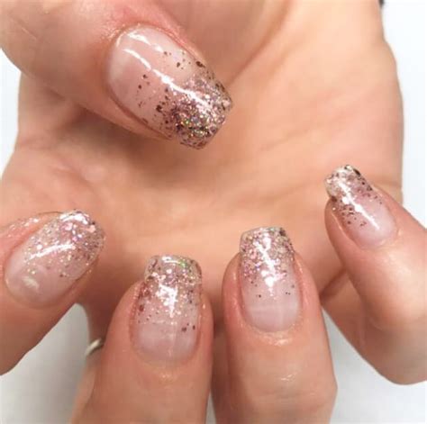 Une manucure nude avec un dégradé de paillettes argentées