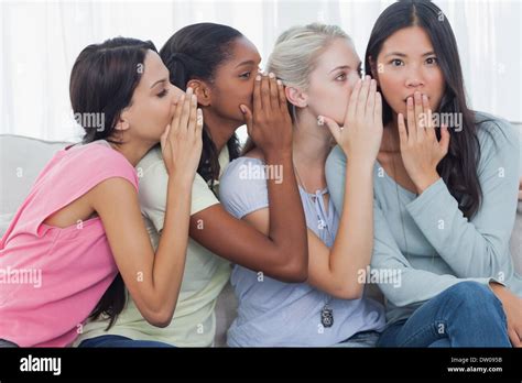 Friends Whispering Secret To Shocked Brunette Stock Photo Alamy