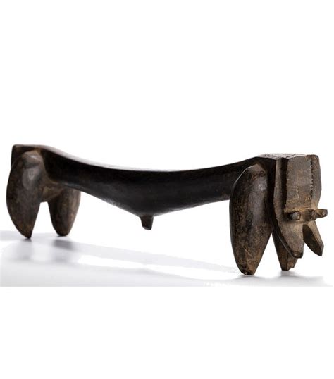 An Old Wooden Bench With Two Faces Carved Into It S Back Legs And Feet