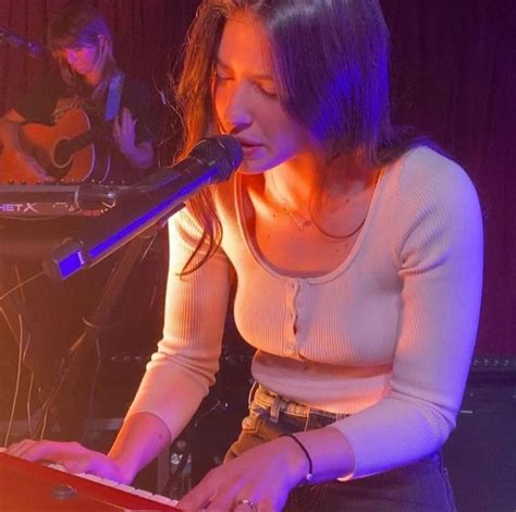 A Woman Sitting In Front Of A Microphone While Holding A Piece Of Paper