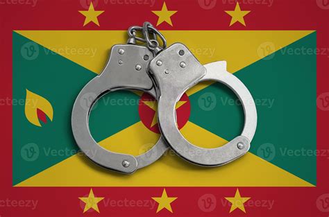 Grenada flag and police handcuffs. The concept of observance of the law