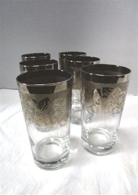 Six Glasses Sitting On Top Of A White Tablecloth Covered Table Next To