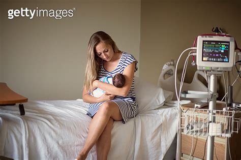 Mother Holding Her Newborn Premature Baby In A Hospital Room