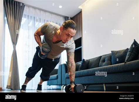 Man doing dumbbells plank row exercise Stock Photo - Alamy