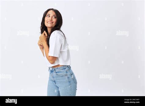 Woman In White T Shirt On White Background Brunette Hands Up Gestures And Signals Poses In Jeans