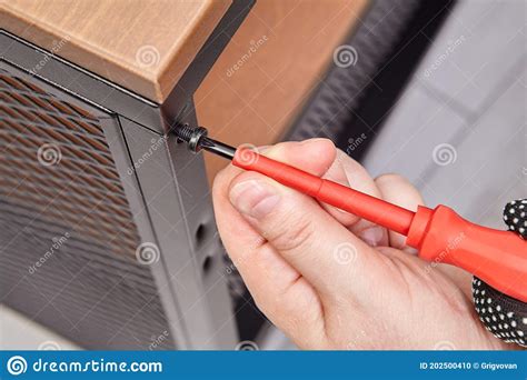 Handyman Is Assembling Metal Flat Pack Furniture Using Screwdriver