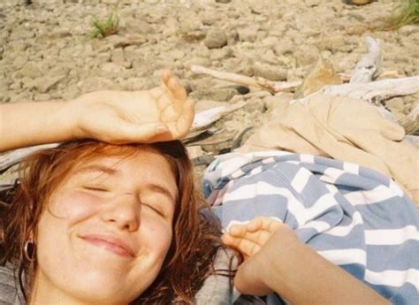 A Woman Laying On The Ground With Her Eyes Closed