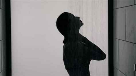 Silhouette Of Side View Of Woman In A Bikini Taking A Shower Stock