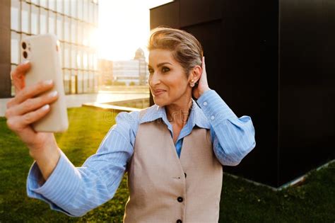Mature Grey Woman Laughing While Taking Selfie On Mobile Phone Stock