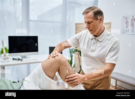 Handsome Mature Doctor In Uniform Helping His Patient To Stretch During