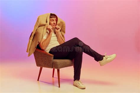 Portrait Of Mature Middle Aged Man Posing Sitting On Chair And Hiding