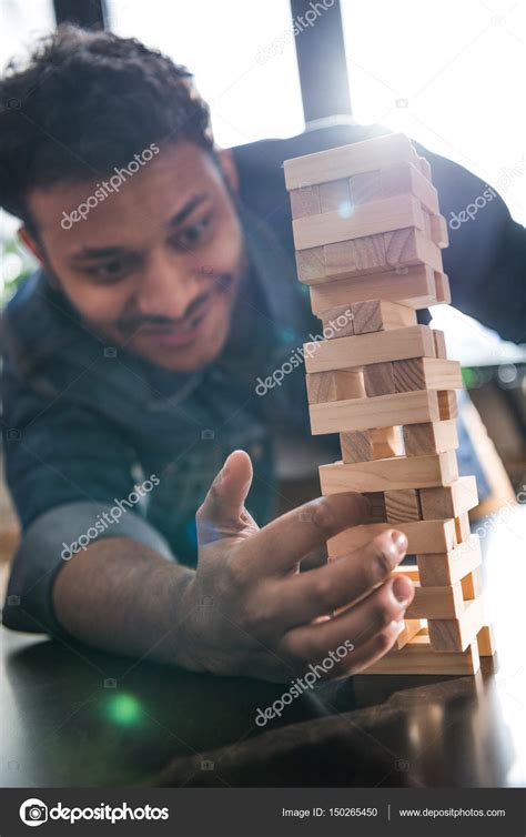 Man playing jenga game — Stock Photo © ArturVerkhovetskiy #150265450
