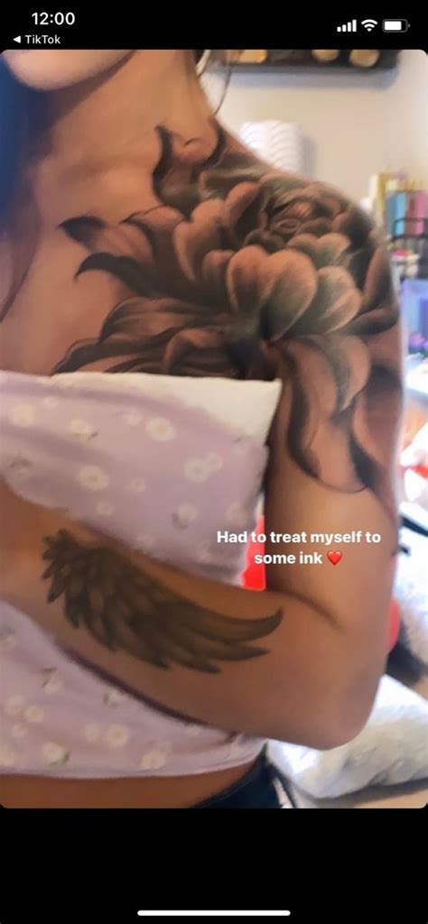 A Woman With Tattoos On Her Arms And Chest Holding A Pillow In Front Of