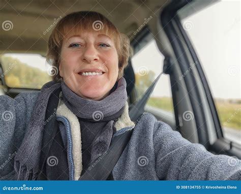 A Funny Cute Blonde Girl Or A Middle Aged Woman Driving A Car In Summer