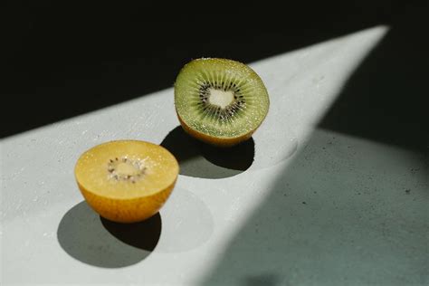 Sliced ripe green and yellow kiwi on table · Free Stock Photo