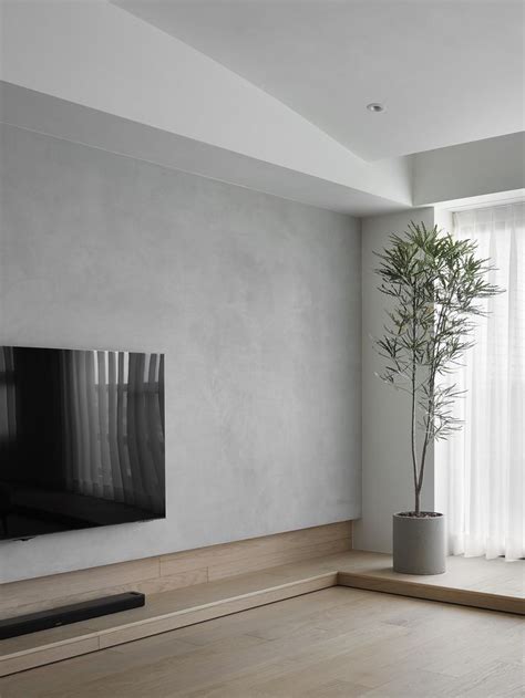 An Empty Living Room With A Plant In The Corner And A Flat Screen Tv On