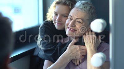 Una Adolescente Abraza A Su Hermosa Abuela Con Pelo Gris Sentada Al