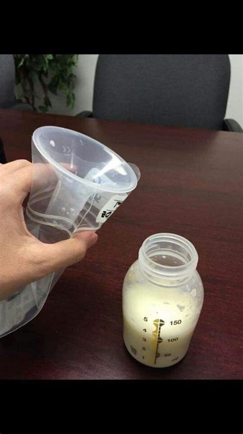 A Person Holding A Measuring Cup Over A Table