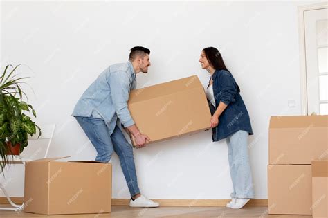 Premium Photo Happy Young Couple Carrying Big Cardboard Box With