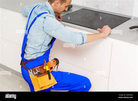 A Worker Repairs An Electric Stove Induction Stove Stock Photo Alamy