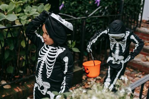 Kids trick or treating in Halloween in skeleton costumes · Free Stock Photo