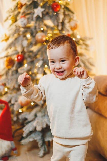 Um menino de 1 ano de idade decora a árvore de natal ano novo árvore de