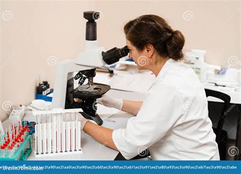 Laboratory Assistant Looks Into Microscope And Makes Blood Test In The