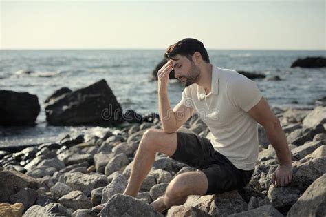 Homem Apenas Triste Que Senta Se Em Uma Praia Do Mar Imagem De Stock