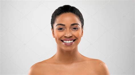 Retrato de feliz hermosa mujer negra semidesnuda sonriendo a la cámara