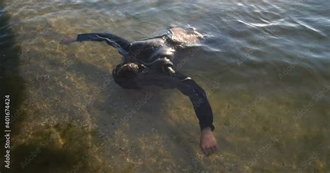 Drowned Man With Long Dark Hair In The Water Sways In The Muddy Water