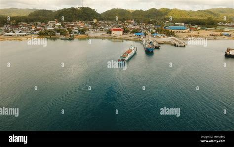 Cargo And Passenger Port With Barges And Cargo Ships On Tropical Island