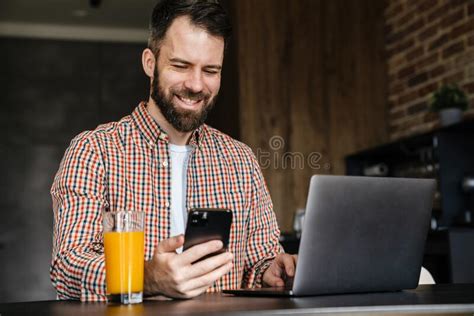 Happy Mid Aged Brunette Bearded Man Sitting At The Table Stock Image