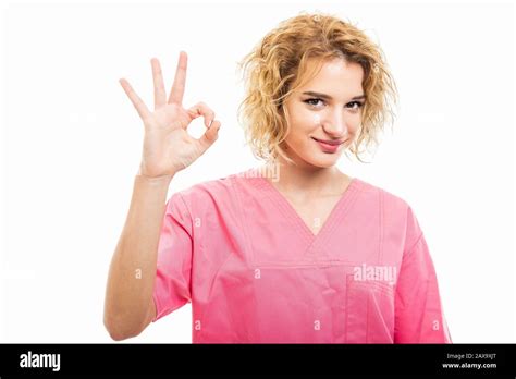 Portrait Of Nurse Wearing Pink Scrub Showing Ok Gesture Isolated On