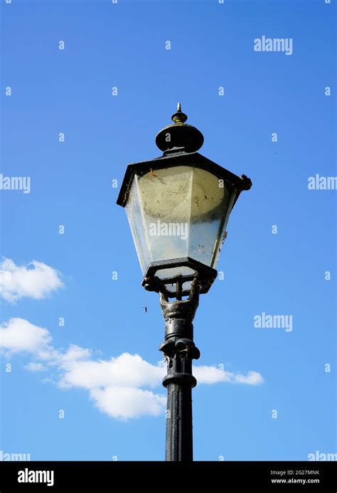 Old Black Metal Street Lamp Blue Sky With Clouds In The Background