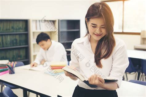 年轻的亚洲学生在图书馆读一本书教育理念图片 包图网企业站