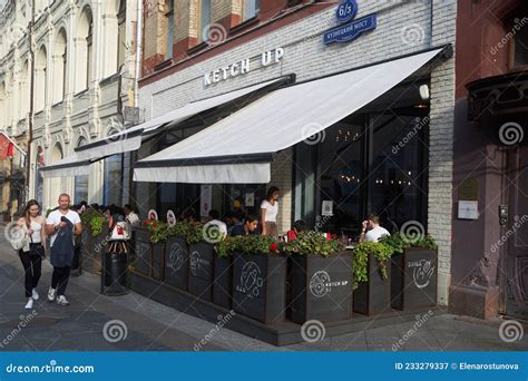 People Have Lunch At A Street Cafe On A Veranda In The City Center On A