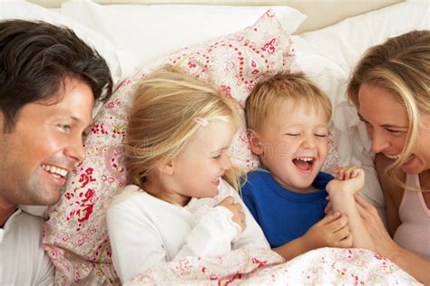 Familia Que Se Relaja Junto En Cama Imagen De Archivo Imagen De Madre