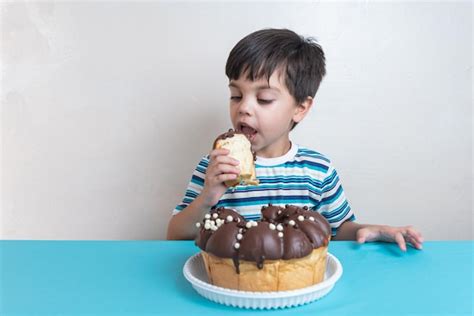 Lindo Adorable Chico En Estudio Comiendo Pastel De Chocolate Foto Gratis