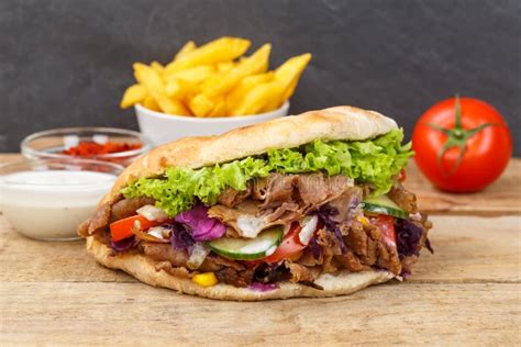 DÃner Kebab Doner Kebap Fast Food in Flatbread with Fries on a Wooden