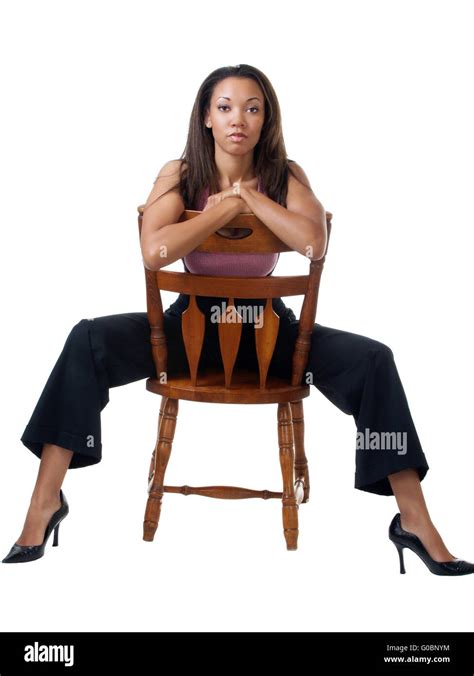 Young Black Woman In Pants Outfit Sitting On Chair Backwards Stock