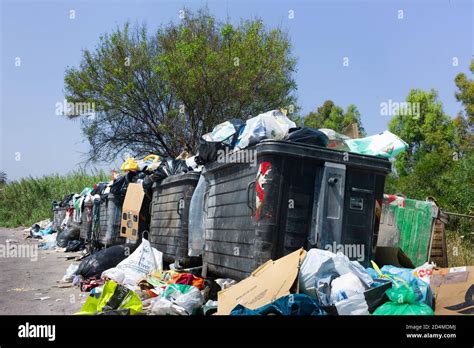 Overflowing Garbage Containers And Torn Open Garbage Bags On The Verge