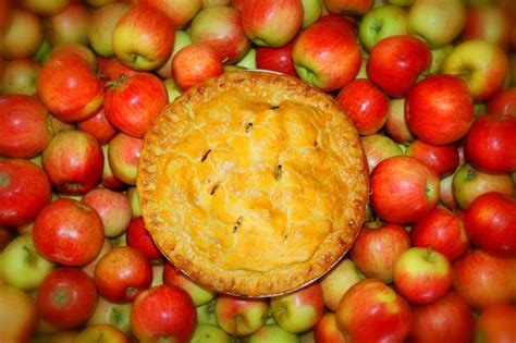 An Apple Pie Surrounded By Many Red Apples