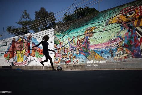 A girl plays soccer in front of graffiti created by acclaimed local ...