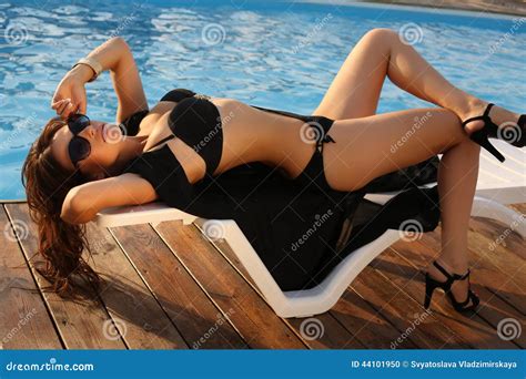 Girl With Dark Hair In Black Bikini Relaxing On Beach Stock Photo