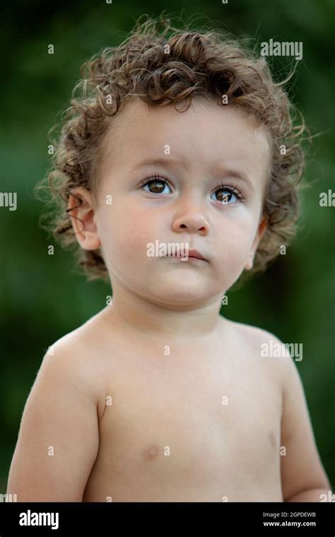 Beautiful Baby With Curly Hair In The Garden Without T Shirt Stock